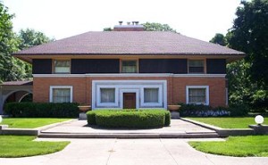 温斯洛住宅:一幢有矩形底座和三角形屋顶的房子，有两层不同的楼层，白色的前门和深色的门，两种色调的砖立面。