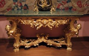 一张巴洛克风格的镀金桌腿和玻璃桌面。