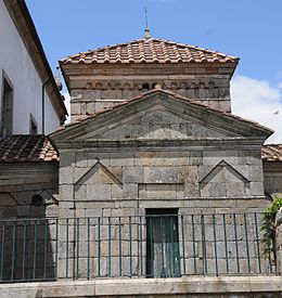 葡萄牙圣福尔图索教堂的照片，这是一个巨大的石头建筑，没有窗户，前面有围栏。