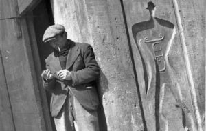 勒·柯布西耶(Le Corbusier)站在一个模数人(Modulor Man)的混凝土浮雕上。