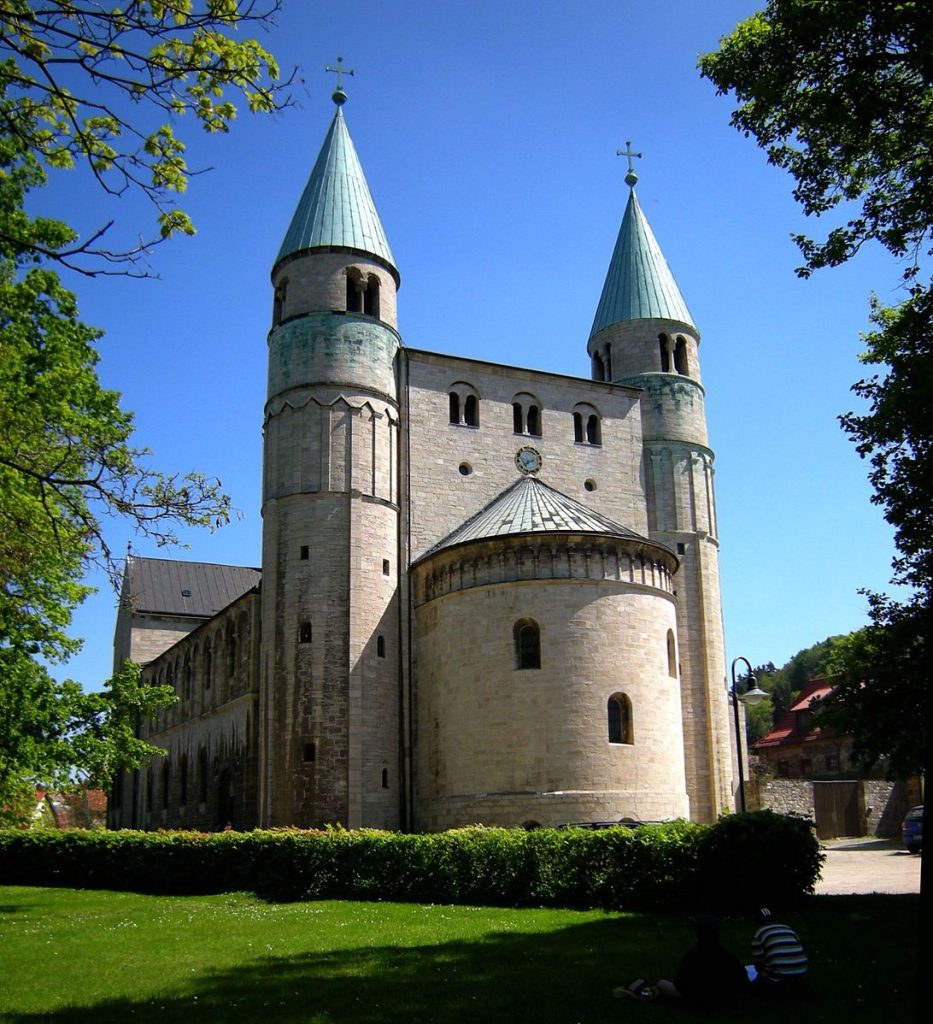 Gernrode的St. Cyriakus西城:一个半圆形圆顶的大建筑，两边有尖塔环绕。
