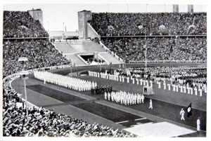 德国奥运代表队在柏林奥林匹克体育场行进(1936年):体育场的黑白照片。
