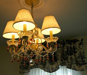 法式乡村风格吊灯:一种小灯具，上面有四盏灯和四个灯罩。