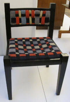 Tessuti di Gunta短距起落zl su una sedia di Marcel Breuer (1922): Sedia imbottita a scacchiera con gambe in legno scuro.