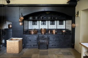 工业风格厨房内饰，黑色橱柜和金色厨具。