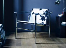 LC1扶手椅(20世纪20年代末)，由Le Corbusier, Pierre Jeanneret和Charlotte Perriand设计:带有奶牛印花坐垫的细金属椅。
