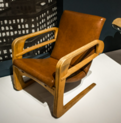 航空椅——凯姆·韦伯:带有棕色靠垫的棕色椅子。