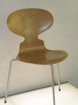 Ant chair 00: A light brown wood chair with three legs.