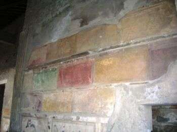 萨勒斯特家族-庞贝。墙壁铺设彩色大理石(黄色、红色和绿色占据了照片的大部分)。