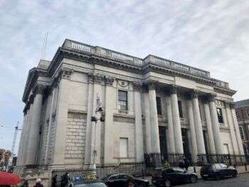都柏林市政厅的照片，这是一座明亮的大建筑，前面有四根粗壮的柱子。