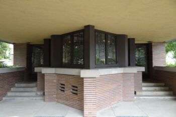 Robie House (Frank Lloyd Wright): A close up photo of the porch with two entrances on either side of a window center piece.