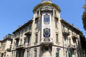 都灵——菲诺格里奥-拉弗勒之家:一座带有装饰性窗户和中央角楼的浅色建筑。